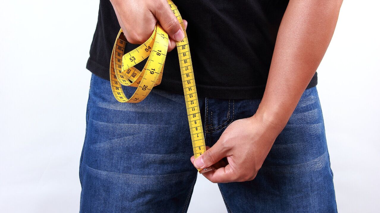 man measuring penis before enlargement